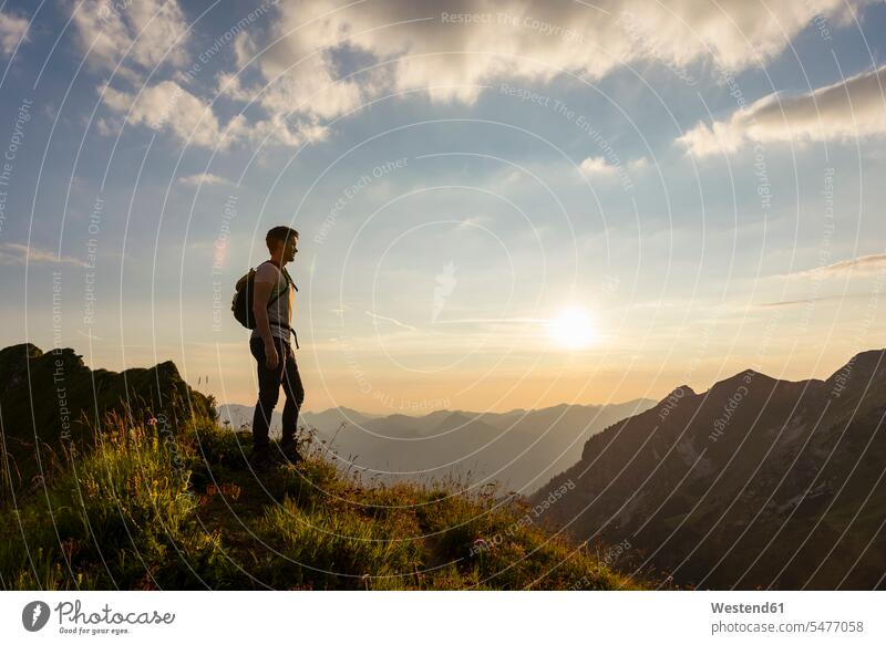 Deutschland, Bayern, Oberstdorf, Mann auf einer Wanderung in den Bergen mit Blick auf den Sonnenuntergang wandern Aussicht Ausblick Ansicht Überblick Männer