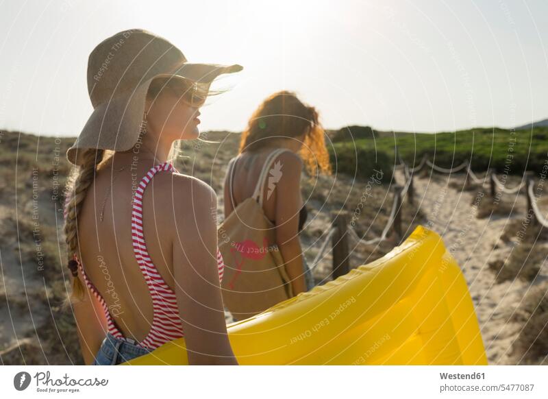 Junge Frauen gehen zum Strand Luftmatratzen Brillen Sonnenbrillen gehend geht sommerlich Sommerzeit gelbe gelber gelbes frei Muße Miteinander Zusammen