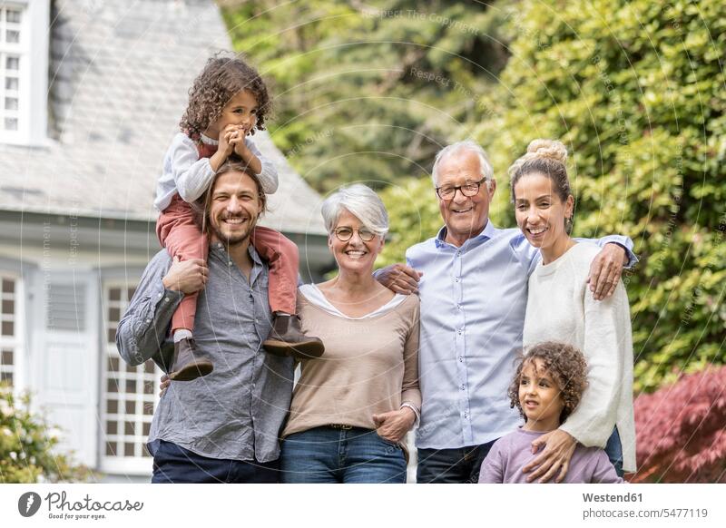 Glückliche Großfamilie steht im Garten ihres Hauses Generation Leute Menschen People Person Personen Familien Mehr Generationen Familien
