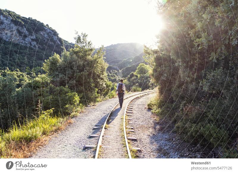 Griechenland, Pilion, Milies, Rückenansicht eines Mannes, der entlang der Schienen der Schmalspurbahn geht Gleis Eisenbahngleise Geleise Gleise Bahngleis