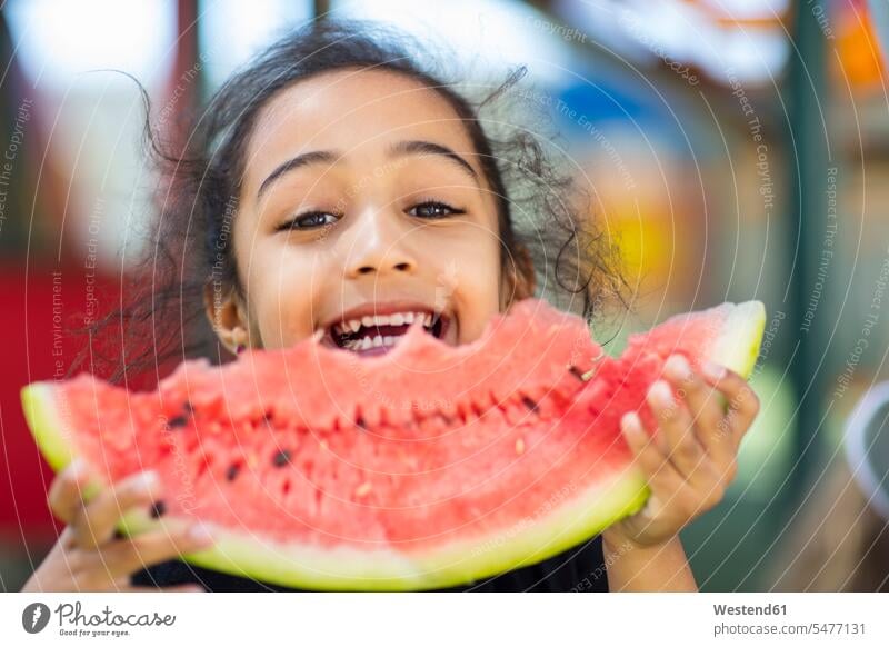 Porträt eines glücklichen Mädchens, das im Kindergarten eine Wassermelone isst Portrait Porträts Portraits weiblich essen essend Kindergaerten Kindergärten