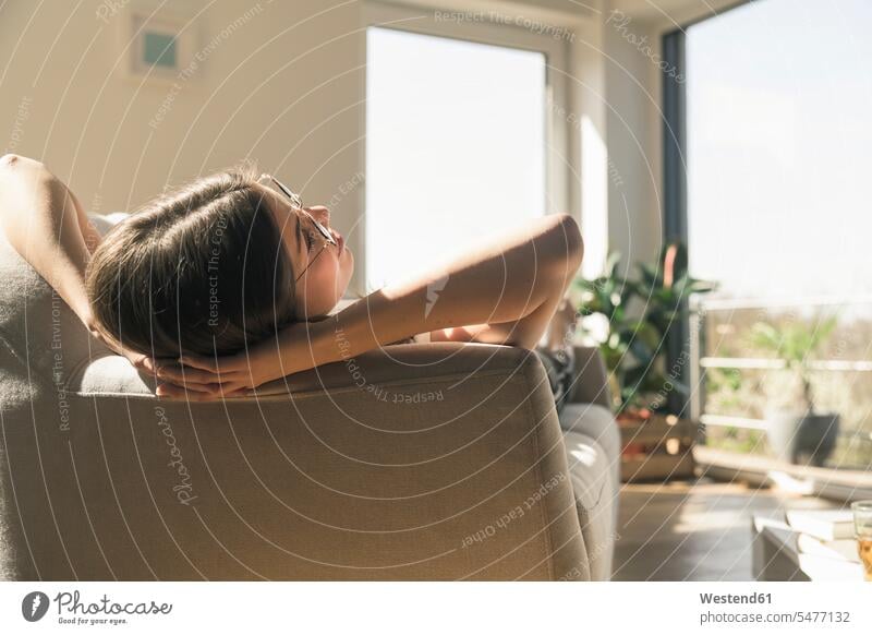 Entspannte junge Frau auf Couch liegend Single Alleinstehende Unverheirateter Singles Alleinstehender Wohnung wohnen Wohnungen Hand hinter dem Kopf