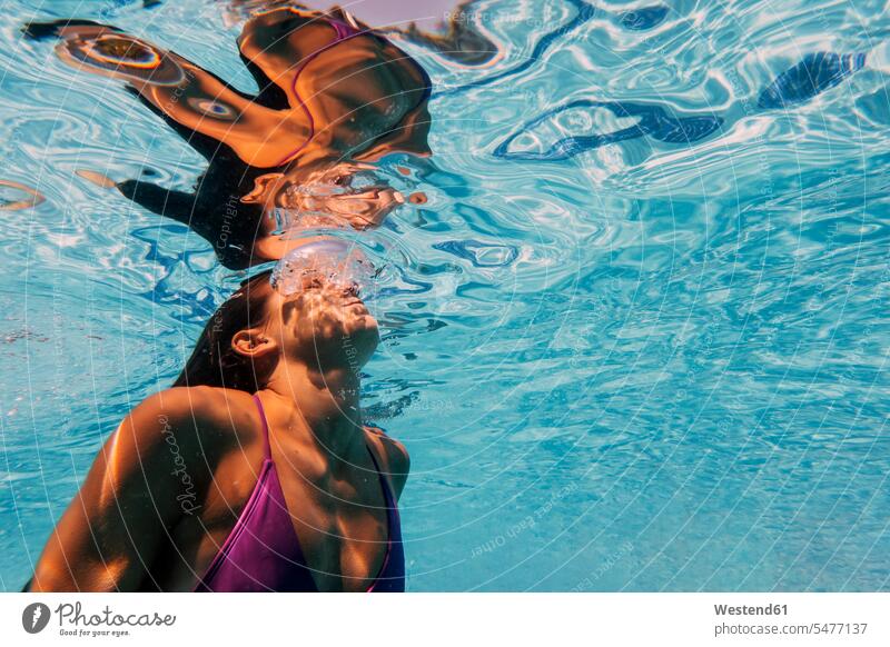 Frau unter Wasser in einem Pool Badebekleidung Badeanzuege Badeanzüge sommerlich Sommerzeit freuen geniessen Genuss leicht Luftblasen Schwimmsport erfrischen