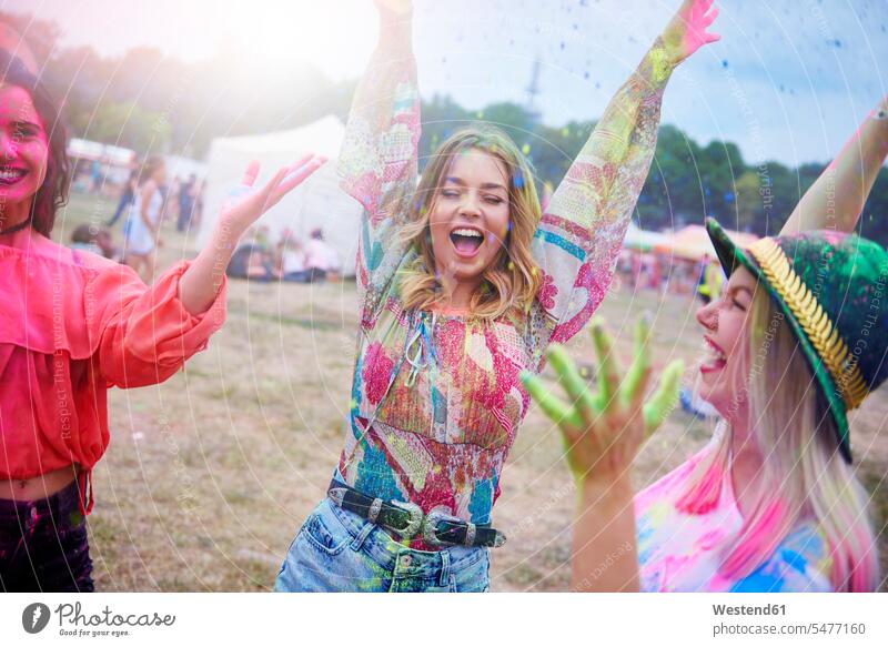 Freunde tanzen während des Musikfestivals, Farbpulver Freundinnen ausgelassen Ausgelassenheit Pulver Pulverfarbe tanzend Musiktage Musikfestspiele Portrait