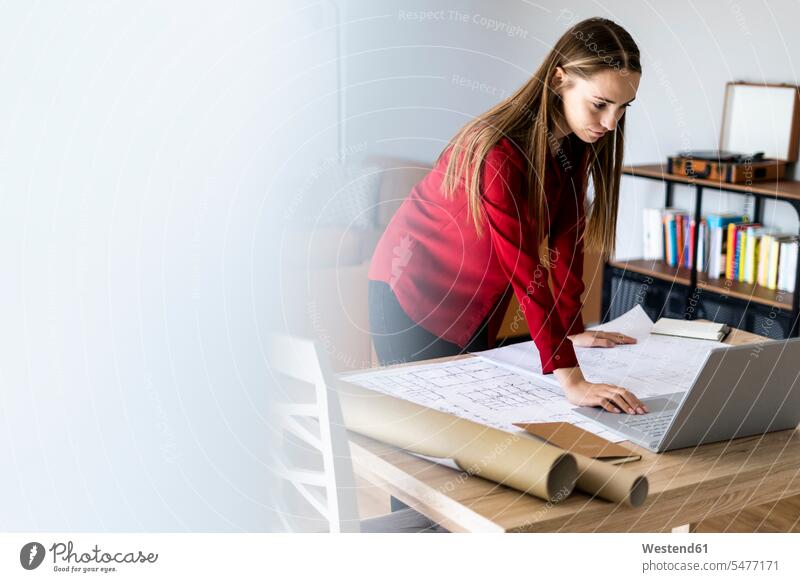 Frau im Büro arbeitet an einem Plan und Laptop auf dem Tisch Leute Menschen People Person Personen Europäisch Kaukasier kaukasisch erwachsen Erwachsene Frauen