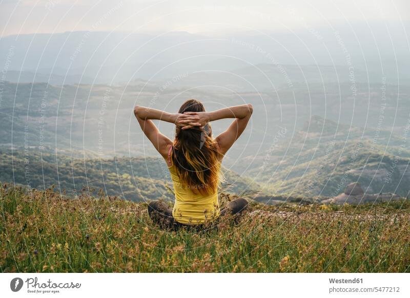 Spanien, Barcelona, Rückenansicht einer jungen Frau, die sich auf dem Berg Montcau entspannt Berge weiblich Frauen Entspannung relaxen entspannen Erwachsener