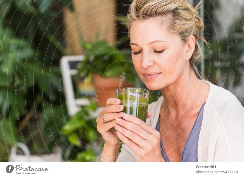 Bildnis einer reifen Frau mit geschlossenen Augen und grünem Smoothie-Glas Gläser Trinkglas Trinkgläser entspannen relaxen geniessen Genuss daheim zu Hause Muße