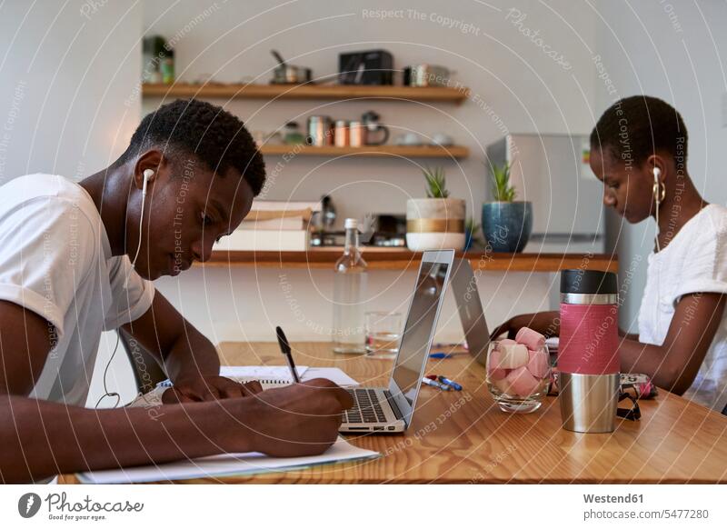Junges Paar lernt zu Hause auf dem Tisch Farbaufnahme Farbe Farbfoto Farbphoto Mosambik Republik Mosambik Afrika Innenausstattung Wohnraum Wohnungseinrichtung