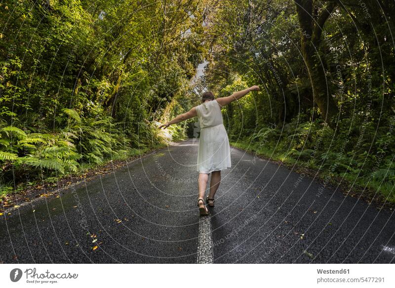 Neuseeland, Nordinsel, Egmont National Park, Frau balanciert auf Mittellinie auf Straße weiblich Frauen Fernweh Reiselust Strassen Straßen Mittelstreifen