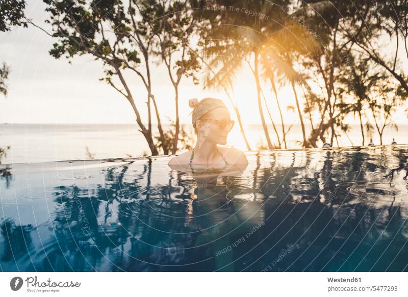 Frau im Infinity-Pool bei Sonnenuntergang, Nai Thon Beach, Phuket, Thailand Brillen Sonnenbrillen entspannen relaxen abends Jahreszeiten sommerlich Sommerzeit