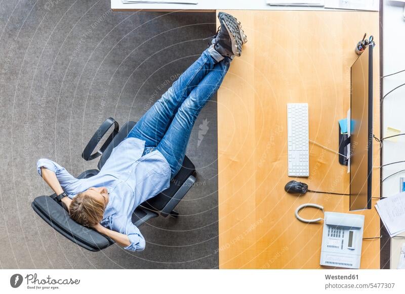 Draufsicht auf Frau entspannt in Stuhl am Schreibtisch im Büro Stuehle Stühle Office Büros entspanntheit relaxt Arbeitstisch Schreibtische weiblich Frauen