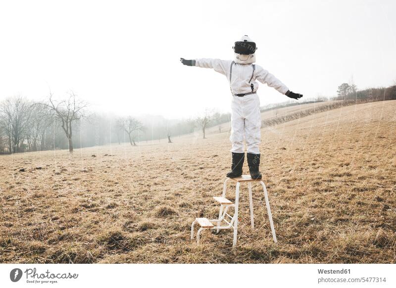 Junge im weißen Raumanzug mit erhobenen Armen auf einer Stufe mit Virtual-Reality-Brille Astronaut Astronauten Virtual Reality Brille Virtual Reality-Brille