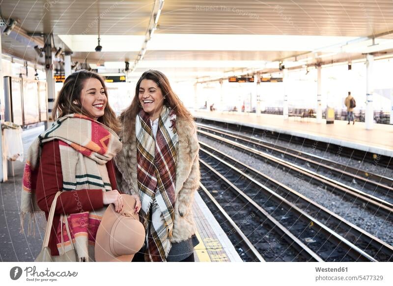 UK, London, zwei glückliche Frauen am Bahnsteig einer U-Bahn-Station Freundinnen U-Bahnhofsbahnsteig U-Bahnhöfe U-Bahnhoefe U-Bahnhofsbahnsteige Bahnsteige