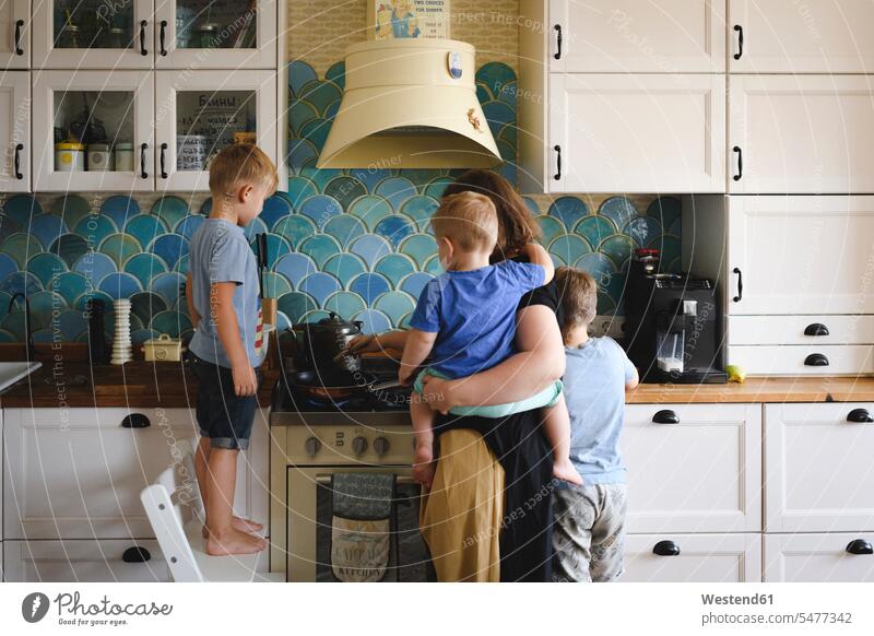 Mutter beim Kochen mit ihren drei Söhnen in der Küche Leute Menschen People Person Personen Europäisch Kaukasier kaukasisch Gruppe von Menschen Menschengruppe