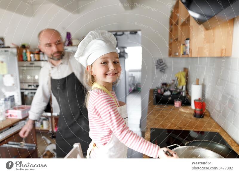 Vater und Tochter kochen in der Küche Herde Kuechenherd Kuechenherde Küchenherd Küchenherde freuen Glück glücklich sein glücklichsein leidenschaftlich