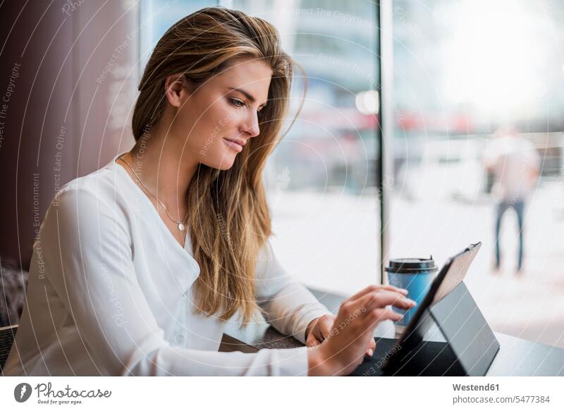 Junge Geschäftsfrau in einem Café mit Tablette Geschäftsfrauen Businesswomen Businessfrauen Businesswoman Tablet Computer Tablet-PC Tablet PC iPad