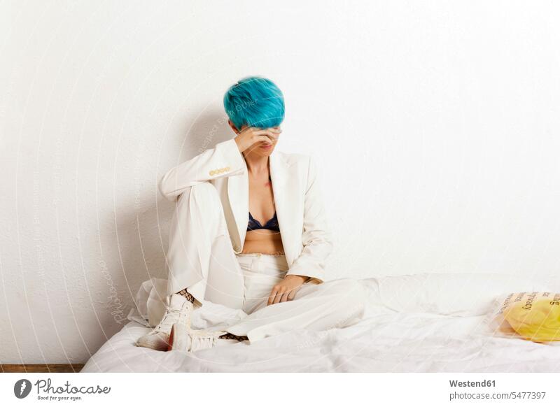 Grunge lesbische Frau sitzt nachdenklich auf dem Bett türkis türkisfarben Lesbe Lesben Lesbierin Homosexuelle Frauen Lesbierinnen weiblich sitzen sitzend denken