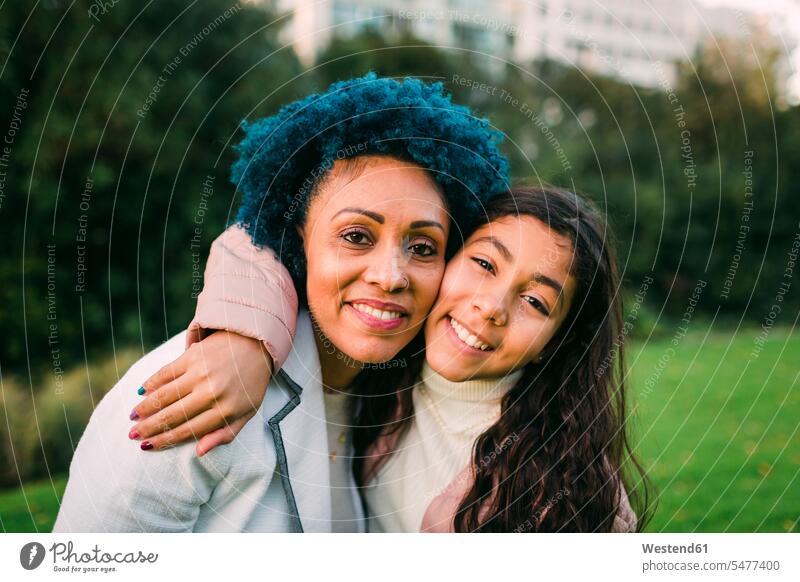 Lächelnde Tochter umarmt Mutter im Park Farbaufnahme Farbe Farbfoto Farbphoto Portugal Freizeitbeschäftigung Muße Zeit Zeit haben Freizeitkleidung