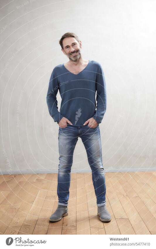 Porträt eines lächelnden Mannes, Best Ager Hemden Hosen Jeanshose freuen Glück glücklich sein glücklichsein zufrieden stehend steht Waende Wände frontal