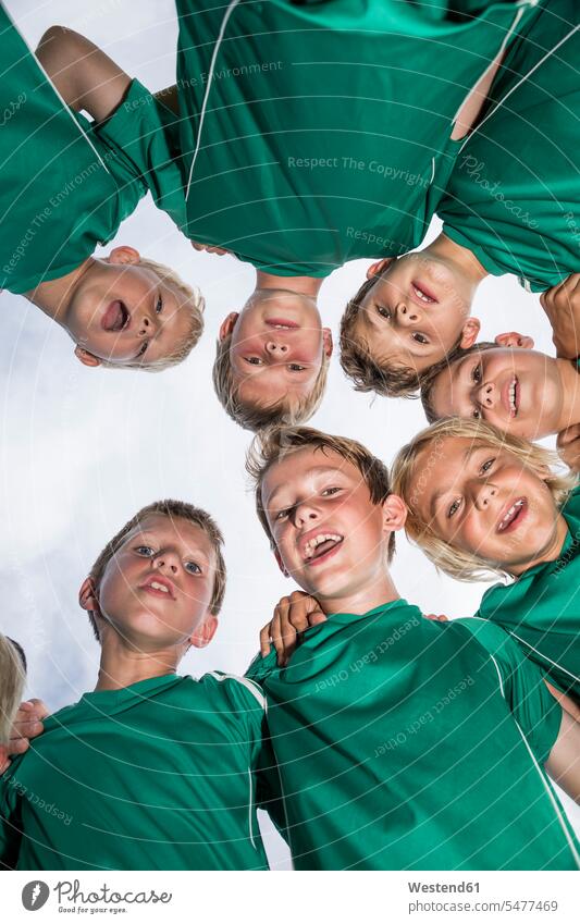 Glückliche junge Fussballspieler kauern sich zusammen Fußball Junge Buben Knabe Jungen Knaben männlich zusammendrängen einen Kreis bilden Huddle