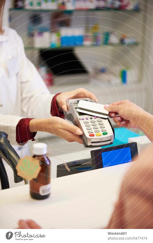 Kunde, der in einer Apotheke bargeldlos mit Kreditkarte bezahlt Kunden Kundschaft Drogerien Apotheken bezahlen EC-Karte Kreditkarten Mensch Menschen Leute
