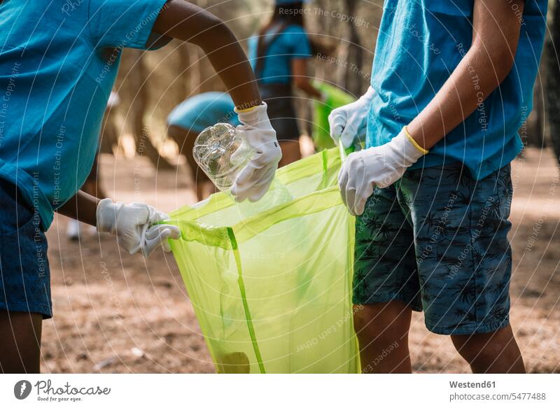 Nahaufnahme von freiwilligen Kindern, die Müll in einem Park sammeln Leute Menschen People Person Personen Europäisch Kaukasier kaukasisch Nordafrikanisch
