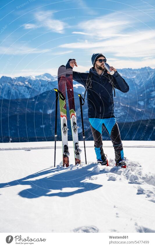 Deutschland, Bayern, Brauneck, Mann auf Skitour im Winter in den Bergen beim Pausieren Männer männlich Pause winterlich Winterzeit Skitouren Tourenski