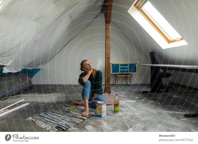 Junge Frau sitzt auf dem Boden im Dachgeschoss mit Farbeimer Deutschland Wohnung Mietwohnungen wohnen Erfrischungsgetränk Erfrischungsgetraenk Softdrink