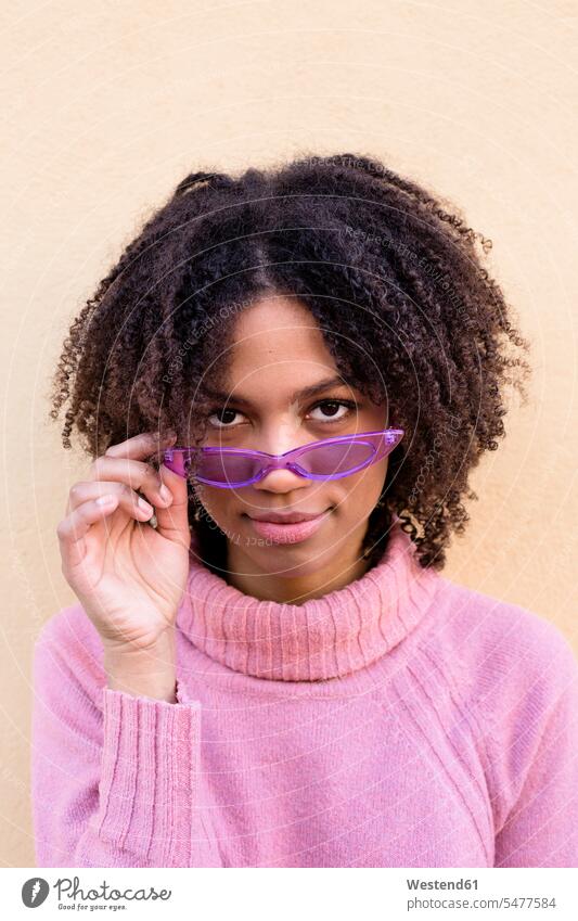 Porträt einer jungen Frau mit rosa Rollkragenpullover und lila Sonnenbrille Portrait Porträts Portraits Pullover rosafarben Sonnenbrillen Brille lilafarben
