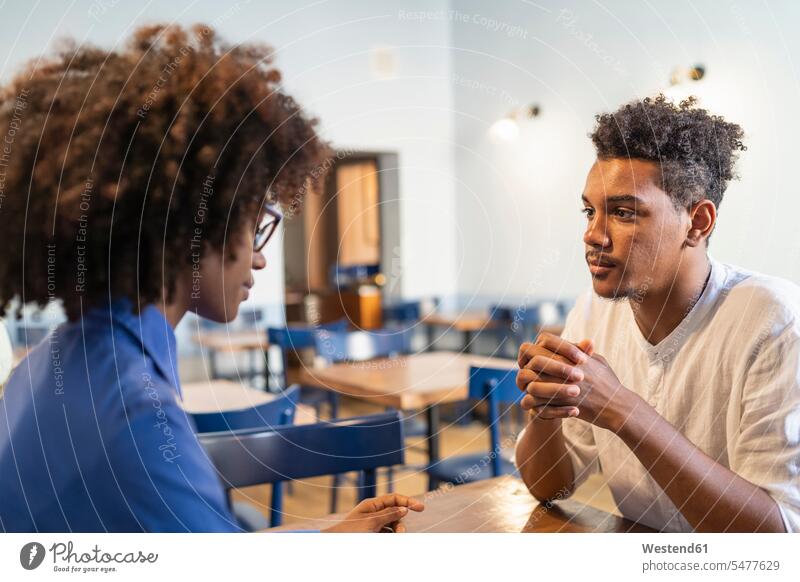 SchülerInnen diskutieren in einem Café über ein Projekt Leute Menschen People Person Personen 2 2 Menschen 2 Personen zwei Zwei Menschen erwachsen Erwachsene