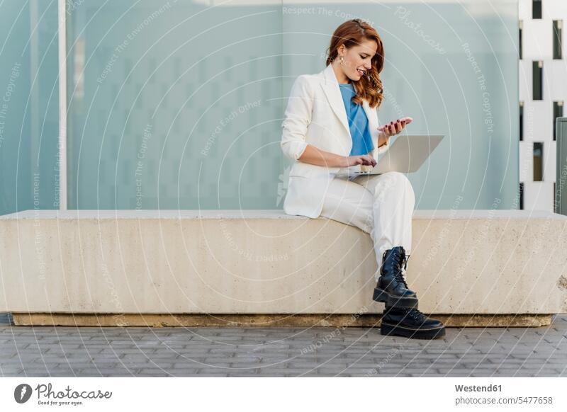 Geschäftsfrau in weißem Hosenanzug, auf Bank sitzend, mit Laptop Job Berufe Berufstätigkeit Beschäftigung Jobs geschäftlich Geschäftsleben Geschäftswelt
