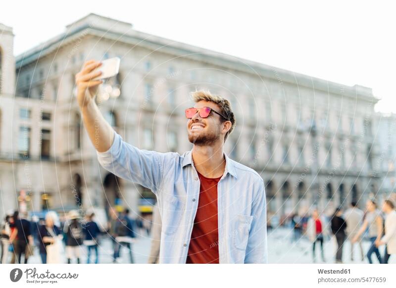Lächelnder junger Mann macht ein Selfie in der Stadt, Mailand, Italien Touristen Hemden Telekommunikation telefonieren Handies Handys Mobiltelefon Mobiltelefone