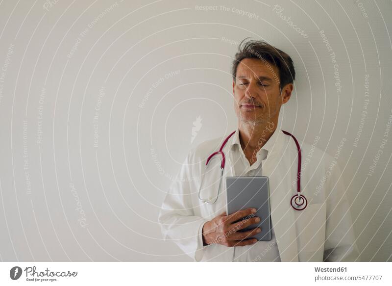 Arzt stehend im Krankenhaus, mit digitalem Tablet Doktoren Ärzte Kliniken Krankenhäuser Krankenhaeuser Portrait Porträts Portraits Stethoskop Stethoskope