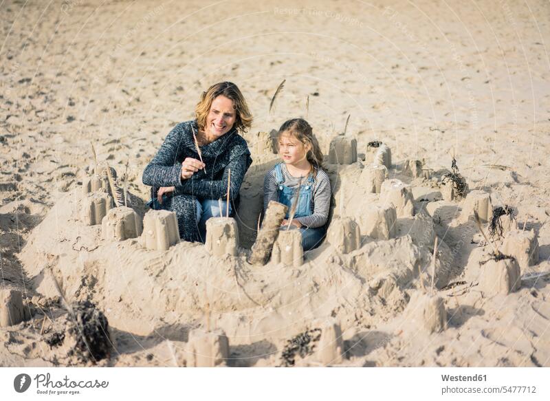 Mutter und Tochter bauen eine Sandburg am Strand Sandburgen Töchter Mami Mutti Mütter Mama spielen sandig Beach Straende Strände Beaches reife Frau reife Frauen