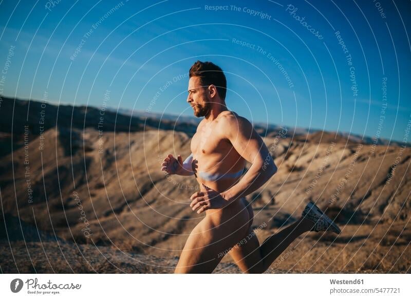 Nackter, schöner Mann rennt in der Wüste gegen den blauen Himmel Farbaufnahme Farbe Farbfoto Farbphoto Spanien Freizeitbeschäftigung Muße Zeit Zeit haben