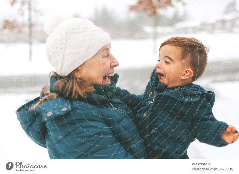 Großmutter und Enkel umarmen sich Jacken Arm umlegen Umarmung Umarmungen Jahreszeiten winterlich Winterzeit begeistert Enthusiasmus enthusiastisch Überschwang