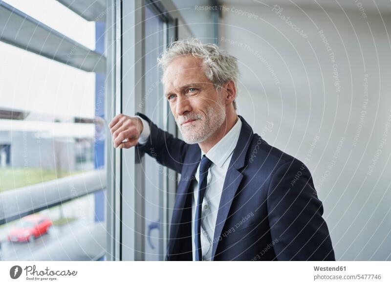 Porträt eines selbstbewussten Geschäftsmannes, der aus dem Fenster schaut Job Berufe Berufstätigkeit Beschäftigung Jobs geschäftlich Geschäftsleben