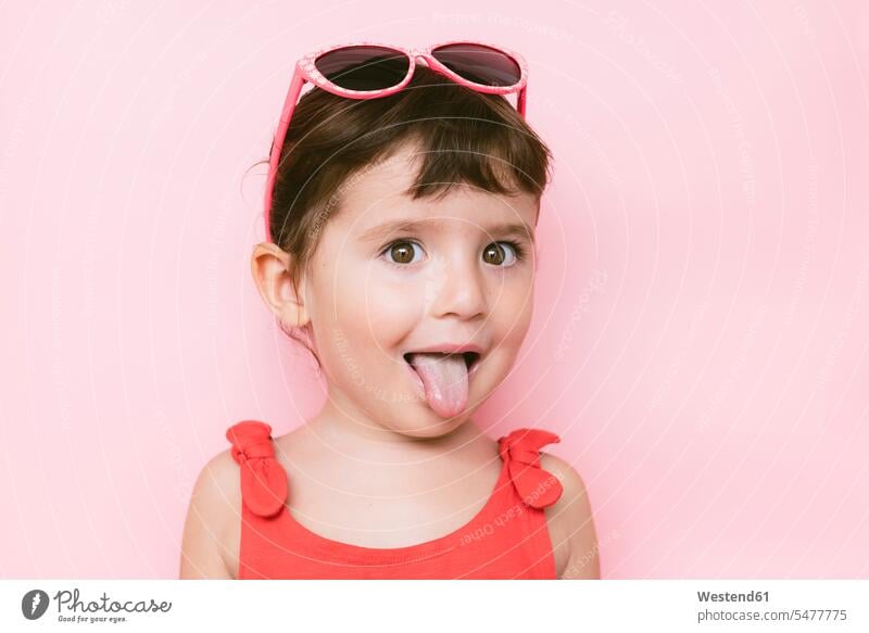Happy little girl with funny face and tongue out on pink background Leute Menschen People Person Personen Europäisch Kaukasier kaukasisch 1 Ein ein Mensch eine