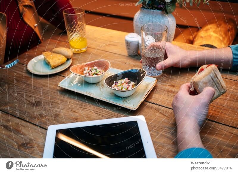 Zwei Menschen sitzen im Restaurant, essen und trinken, mit digitalem Tablet auf dem Tisch drinnen Innenaufnahmen Gastronomie Lokal Lokale Restaurants