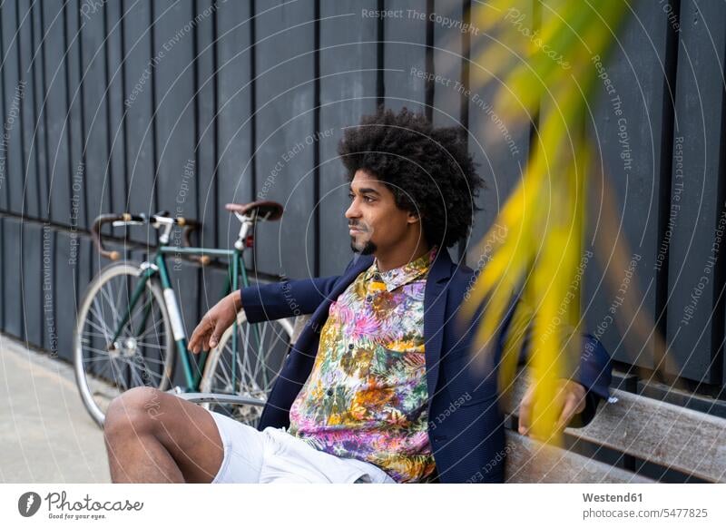 Stilvoller Mann mit Fahrrad sitzt auf einer Bank geschäftlich Geschäftsleben Geschäftswelt Geschäftsperson Geschäftspersonen Businessmann Businessmänner