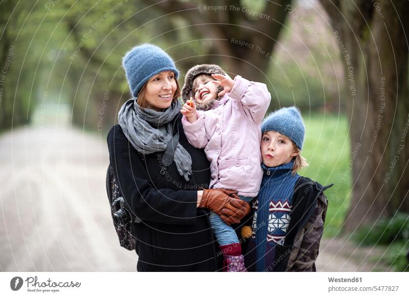 Porträt einer glücklichen Mutter mit Sohn und kleiner Tochter in einem Park Gemeinsam Zusammen Miteinander positiv Söhne ein Elternteil Familie mit zwei Kindern
