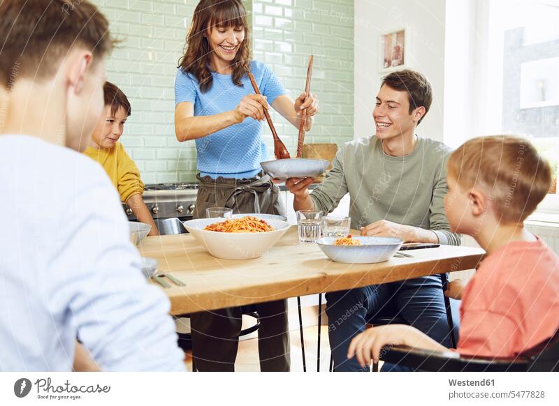 Mutter isst Spaghetti mit ihren Söhnen in der Küche Schale Schalen Schälchen Schüsseln freuen Frohsinn Fröhlichkeit Heiterkeit Glück glücklich sein