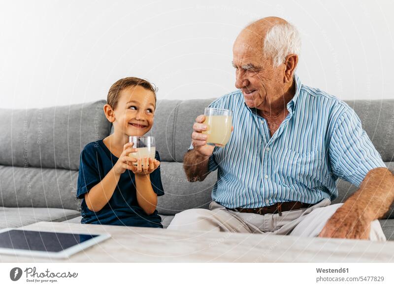 Großvater und Enkel sitzen zusammen auf der Couch und trinken Limonade Sofa Couches Liege Sofas sitzend sitzt Enkelsöhne Enkelsohn Opa Großpapa Großpapas Opas