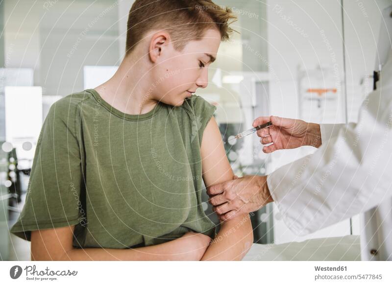 Arzt injiziert Impfstoff in den Arm eines Teenagers Gesundheit Gesundheitswesen medizinisch Erkrankung Erkrankungen Krankheiten Kranke Kranker Patienten Job