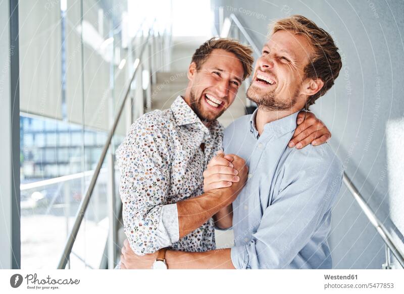 Porträt von zwei glücklichen jungen Geschäftsleuten beim Händeschütteln Leute Menschen People Person Personen 2 2 Menschen 2 Personen Zwei Menschen erwachsen