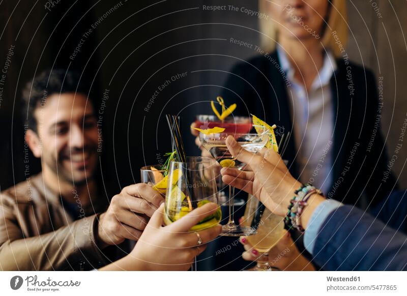 Kollegen stoßen mit Cocktails in einer Bar an Arbeitskollege Arbeitskollegen Job Berufe Berufstätigkeit Beschäftigung Jobs Gläser Trinkglas Trinkgläser freuen