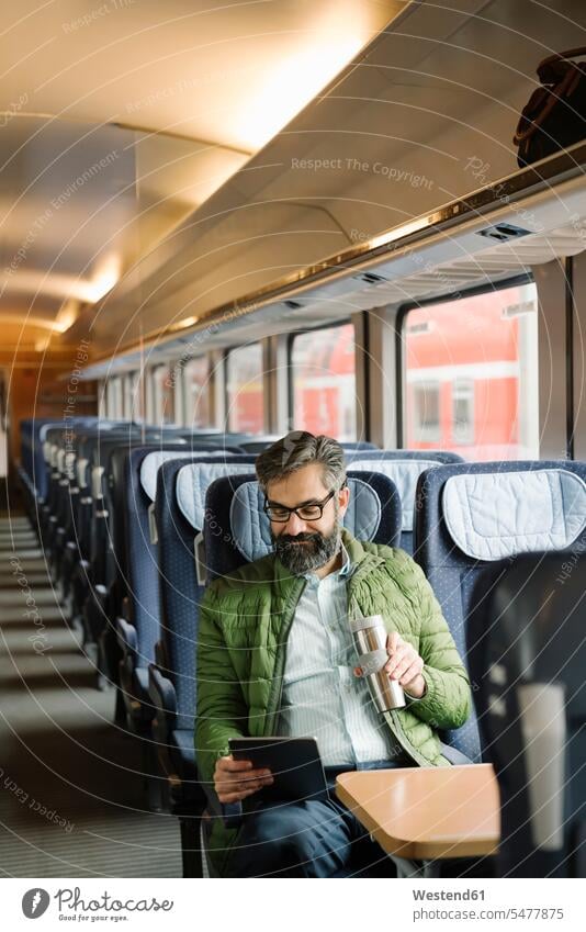Mann sitzt mit Tablette im Zug Job Berufe Berufstätigkeit Beschäftigung Jobs geschäftlich Geschäftsleben Geschäftswelt Geschäftsperson Geschäftspersonen