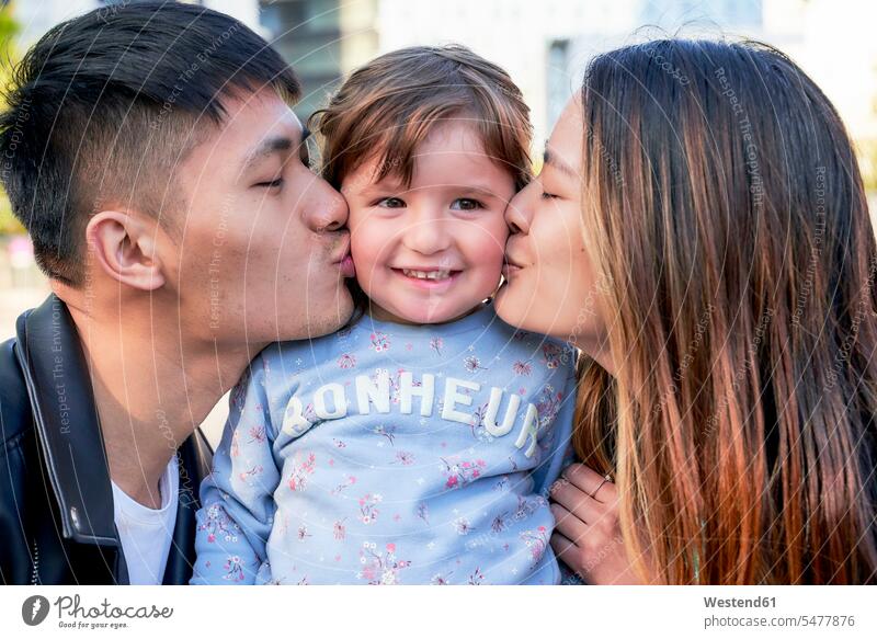 Glückliche Eltern küssen kleines Mädchen Leute Menschen People Person Personen Asiaten Asiatisch asiatische asiatische Abstammung asiatischer asiatisches