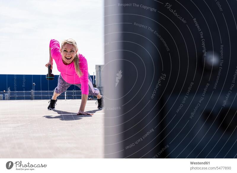 Frau trainiert mit Kurzhanteln, macht einarmige Planke Sportler trainieren Kraft stark Stärke kräftig Hantel Hanteln Gewicht Gewichte Workout sportlich fit
