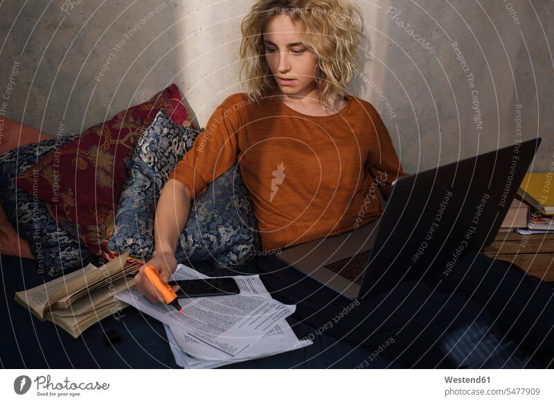 Porträt einer blonden Studentin, die mit Laptop auf dem Bett sitzt und arbeitet Leute Menschen People Person Personen Europäisch Kaukasier kaukasisch 1 Ein
